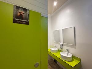 a bathroom with two sinks and a green wall at Safestay Edinburgh Cowgate in Edinburgh