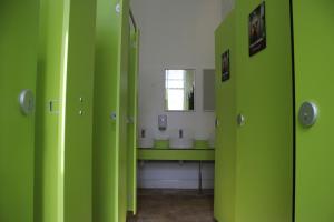 a green bathroom with a sink and a mirror at Safestay Edinburgh Cowgate in Edinburgh