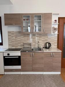 a kitchen with wooden cabinets and a sink at Apartmani Odmor Fojnica in Fojnica