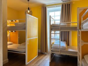 a room with three bunk beds and a window at Safestay Edinburgh Cowgate in Edinburgh