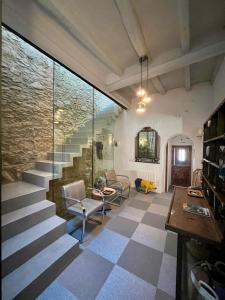 sala de estar con escaleras y pared de piedra en Begur, mon amour, en Begur