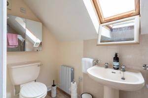 ein Badezimmer mit einer weißen Toilette und einem Waschbecken in der Unterkunft 3-Bed Portballintrae Home | Wi-Fi, Garden, Parking in Portballintrae + 20 Fotos