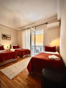 a hotel room with two beds and a balcony at All Seasons Apartments - Free Parking & City Center in Shkodër