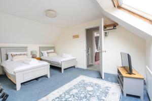 ein Schlafzimmer mit zwei Betten und einem Fernseher in der Unterkunft 3-Bed Portballintrae Home | Wi-Fi, Garden, Parking in Portballintrae