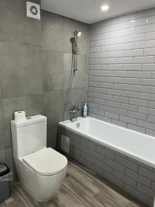 a bathroom with a white toilet and a bath tub at Olimp Sea View 607 in Olimp