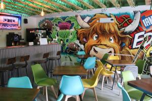 a mural in a restaurant with tables and chairs at Safestay Edinburgh Cowgate in Edinburgh