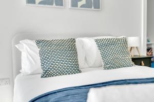 a white bed with two pillows on top of it at The Van Gogh Loft - By Raymond Properties in New Malden