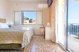 a bedroom with a bed and a balcony at Family House in Lakones in Paleokastritsa