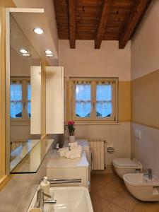 a bathroom with a sink and a toilet at Fiore di LOTO in Paratico