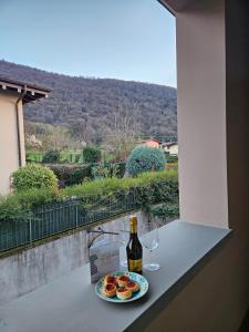 a bottle of wine and a plate of food and wine glasses at Fiore di LOTO in Paratico