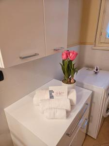 a bathroom with towels and a vase of pink roses at Fiore di LOTO in Paratico +17 photos