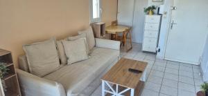 un soggiorno con un divano e un tavolo di La maison du mail, T2, wifi, 300m de la plage a Cap d'Agde