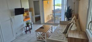 un soggiorno con un divano e un tavolo di La maison du mail, T2, wifi, 300m de la plage a Cap d'Agde