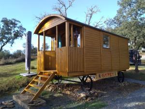 a wooden tiny house sitting on a pile of rocks at Gypsy caravan op de camping in Ourique