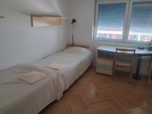 a small bedroom with a bed and a desk at Avocado Apartment in Ohrid