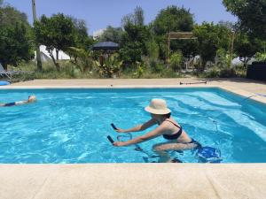 a woman sitting in a swimming pool with a hat at Casa Terapia in Loulé +7 photos
