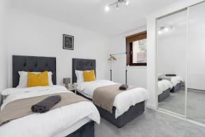 - une chambre avec 3 lits et un miroir dans l'établissement Free Parking - Sleeps 6 - 2 Bedrooms - Newly Renovated, à Greenock