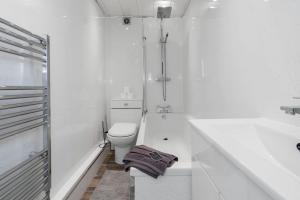 une salle de bain blanche avec toilettes et baignoire dans l'établissement Free Parking - Sleeps 6 - 2 Bedrooms - Newly Renovated, à Greenock