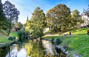 a river in a park with people walking along it at Grunerløkka House - Oslo in Oslo +7 photos