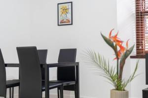 une table à manger noire avec deux chaises et une plante dans l'établissement Free Parking - Sleeps 6 - 2 Bedrooms - Newly Renovated, à Greenock 11 autres photos