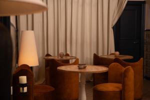 a room with tables and chairs and a lamp at The Honest Hotel & Apartments in Seville