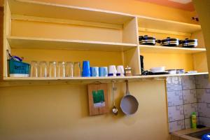 a kitchen shelf with dishes and utensils on it at Khalisee homes studio apartment 3 in Voi