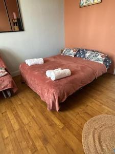 a bedroom with a bed with two towels on it at Les roses à la plage in Veules-les-Roses