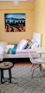 a bedroom with a bed and a table and a chair at Khalisee homes studio apartment 3 in Voi
