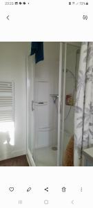 Un baño con ducha con puerta de cristal. en Les roses à la plage, en Veules-les-Roses