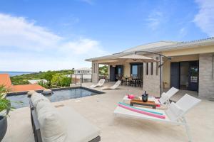 a villa with a swimming pool and a house at Villa Pomelia in Le Carbet