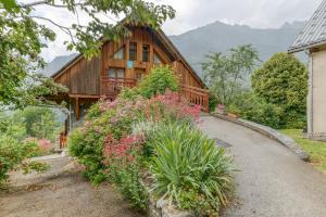 a wooden house with flowers in front of it at Auberge Passoud 203 in Vaujany