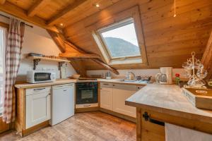 a kitchen with wooden ceilings and a large window at Auberge Passoud 203 in Vaujany +14 photos