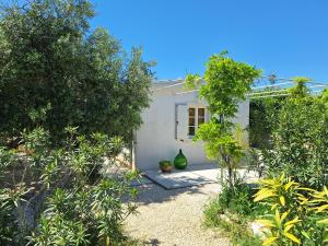 a white house with two green vases in a yard at Villa Elizej in Fažana