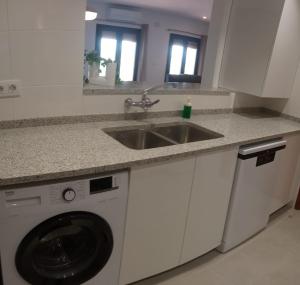 a kitchen with a sink and a washing machine at L'horitzó II in Llado +13 photos