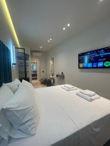 伏罗拉The cosy inn vlora的卧室配有白色的床,墙上配有电视