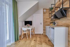 a small kitchen and dining room with a table and chairs at Apartamenty Śniadanie do Łóżka in Pobierowo