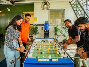 バンガロールにあるThe Hosteller Bangalore, Manyata Tech Parkのテーブルの周りに立つ人々