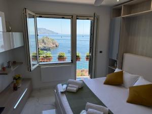 a bedroom with a large window with a view of the ocean at Paradise By The Sea in Taormina +41 photos
