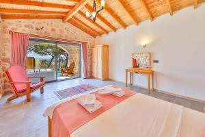 a bedroom with a bed and a desk and a window at Spacious 2BR Stone Villa with Pool & BBQ in Kalkan +39 photos