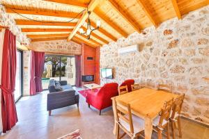 a living room with a wooden table and a stone wall at Spacious 2BR Stone Villa with Pool & BBQ in Kalkan