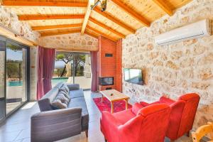 a living room with red furniture and a stone wall at Spacious 2BR Stone Villa with Pool & BBQ in Kalkan