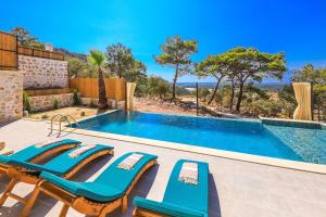 a swimming pool with lounge chairs and a swimming pool at Spacious 2BR Stone Villa with Pool & BBQ in Kalkan