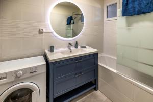 a bathroom with a washing machine and a sink at Appartement paisible au bord de l Isle, parking privé in Périgueux