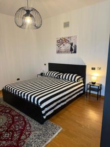 1 dormitorio con 1 cama con edredón de rayas blanco y negro en Blue and Green Apartment, en San Benedetto del Tronto