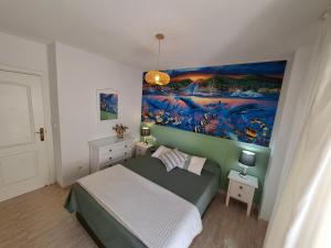 a bedroom with a bed with a painting on the wall at Casa en Urbanización Los Ibicencos in La Manga del Mar Menor