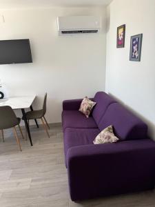 a purple couch in a living room with a table at Apartments Lucijan Međugorje in Međugorje