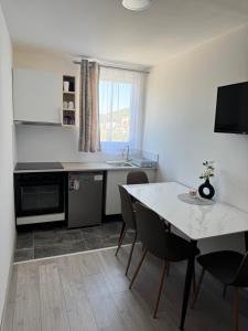 a kitchen with a table and chairs and a sink at Apartments Lucijan Međugorje in Međugorje