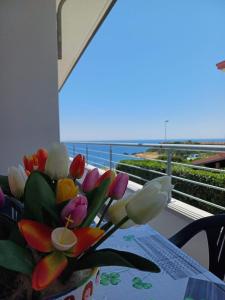 カーポ・リッツートにあるCASA VACANZA SUL MAREの海を背景にテーブルに座る花瓶