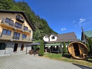 a house with a picnic table and an umbrella in front of it at The Vardo - Elegant Villa in Predelut in Bran
