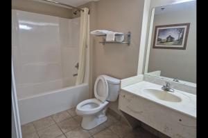 a bathroom with a toilet and a sink and a shower at General Bragg Inn & Suites Chickamauga in Chickamauga